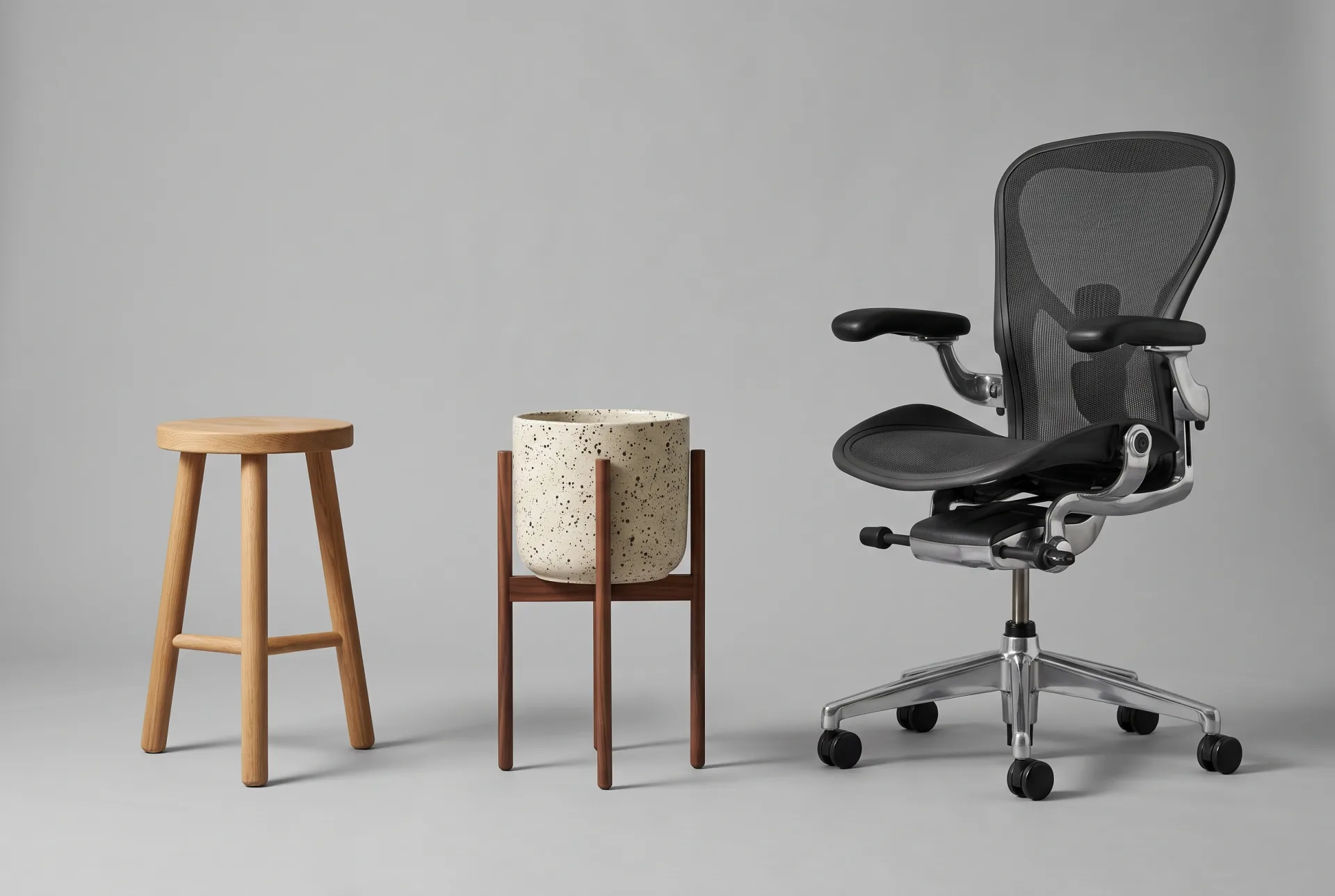 Three product models on a grey backdrop in rising complexity: a plain oak stool, a ceramic plant pot on a walnut stand and a detailed mesh office chair.