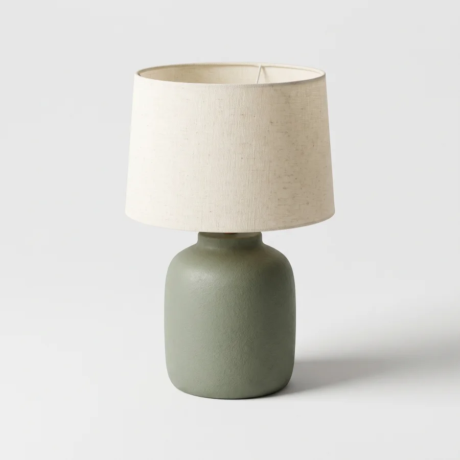 A 3D render of a sage green ceramic table lamp with a cream shade