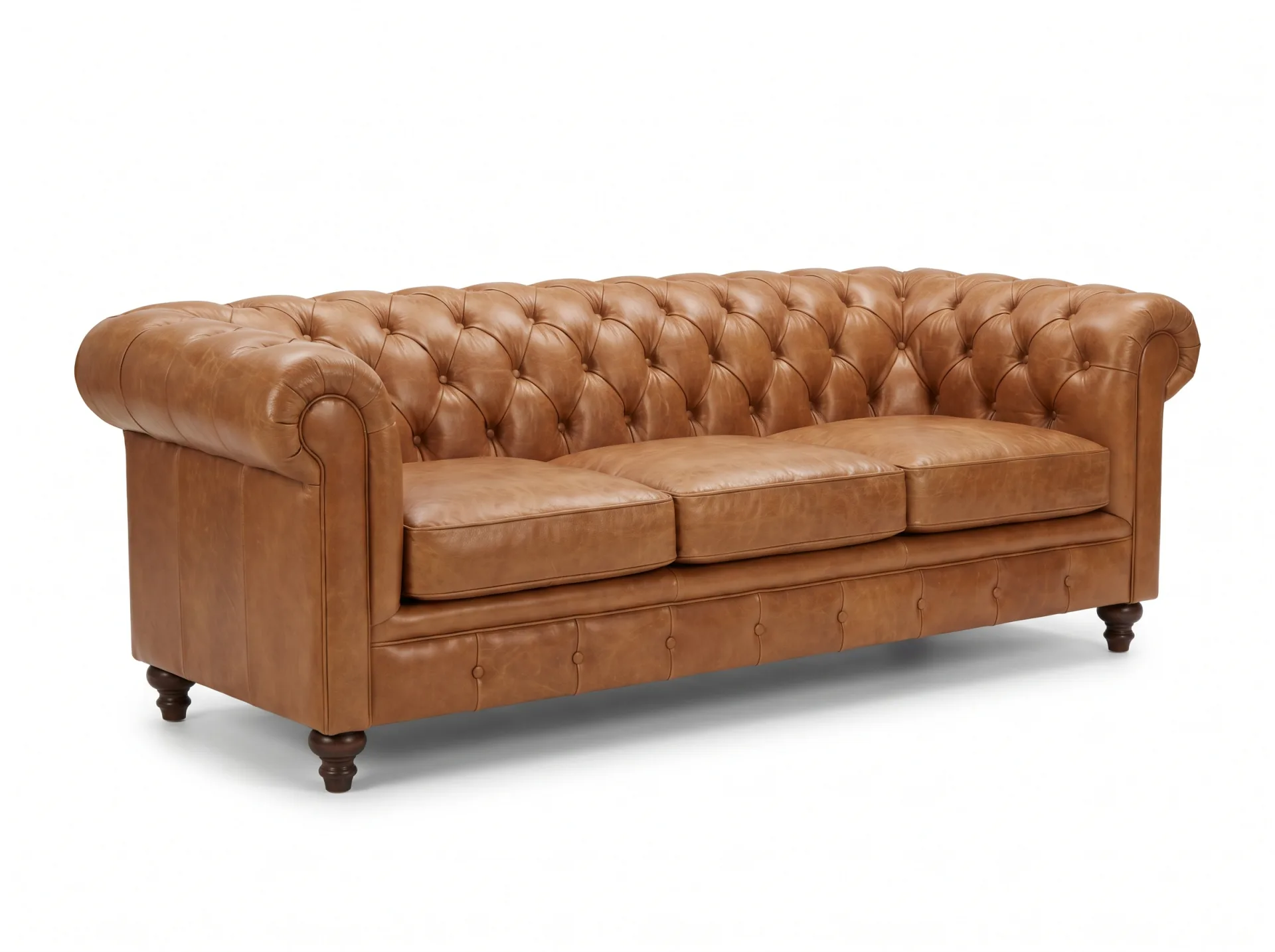 A tan leather chesterfield sofa with button tufting and rolled arms on a pure white background.
