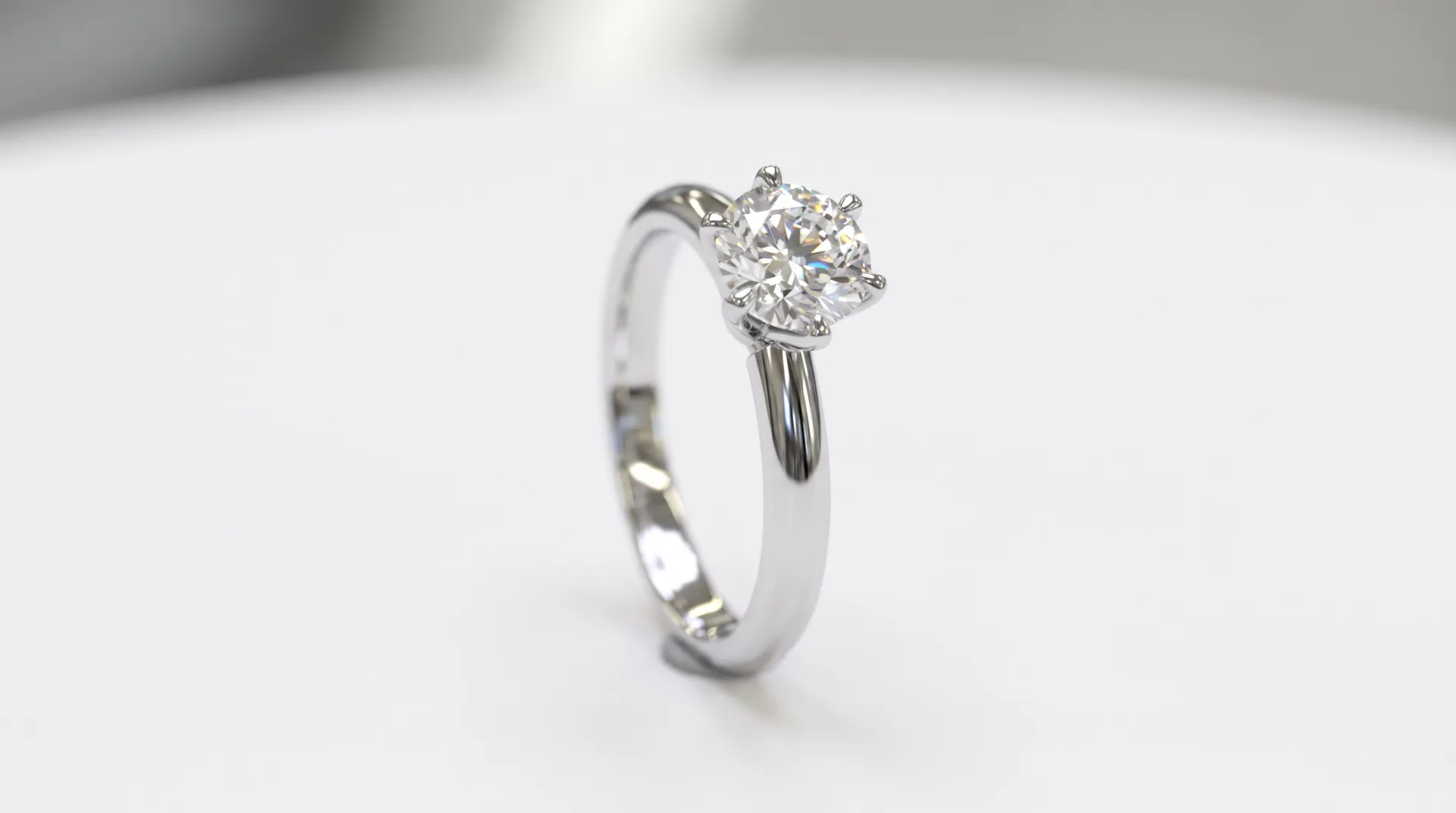 A platinum solitaire ring with a round diamond standing upright on white, the stone showing sparkle and fire.