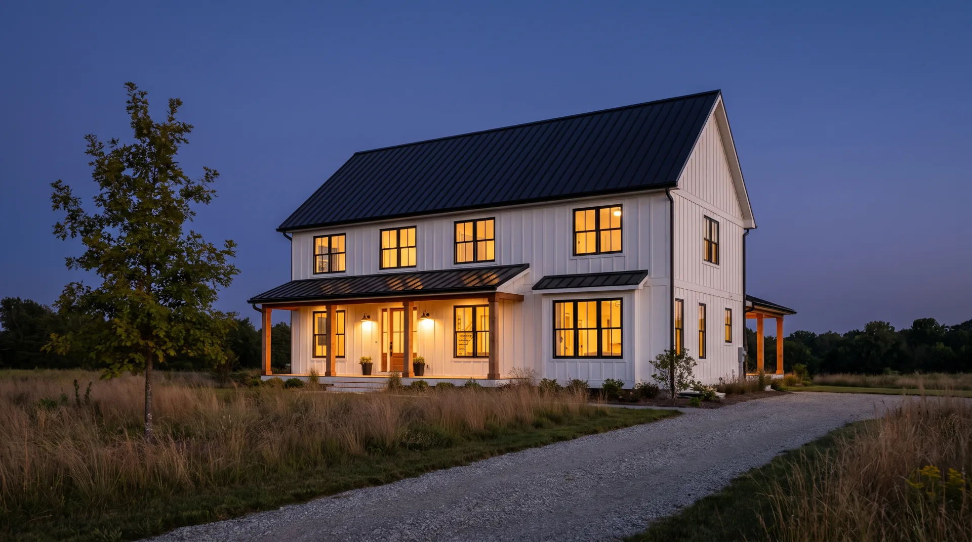 Concept work: a two-story white farmhouse with a black metal roof at dusk, windows lit warm against a deep blue sky.