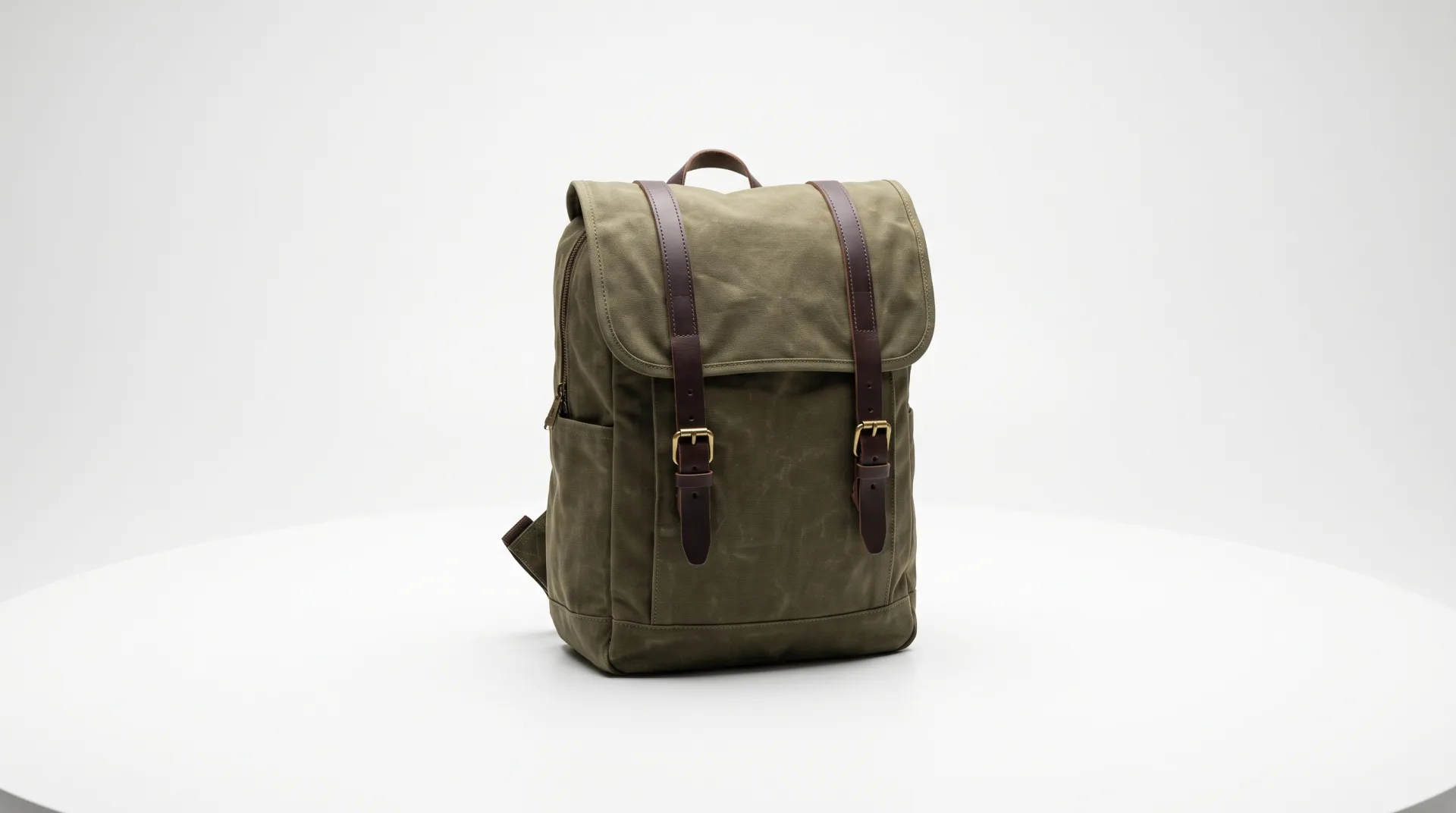 Concept work: a 360-degree loop of an olive waxed canvas backpack with leather straps turning on a white background.